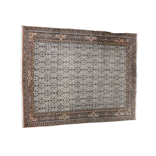 43 - An Ivory ground Yazd style rug with all over multicoloured geometric patterned ground within multico... 