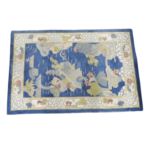 45 - A blue ground Oriental style rug with pictorial decorated ground depicting islands within cream styl... 