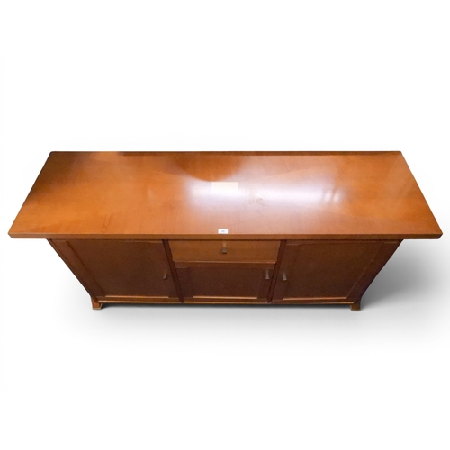49 - A late 20th century cherry wood sideboard with single central drawer and cabinet door flanked by lar... 