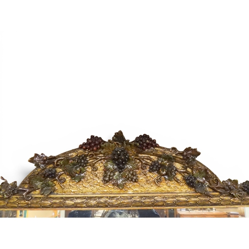 6 - A 20th century gilt framed overmantle mirror with arched surmount decorated with grapes on the vine ... 