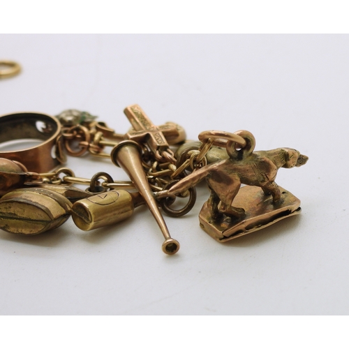 712 - A yellow metal charm bracelet, with twelve 9ct gold charms, seven yellow metal charms, to include a ... 