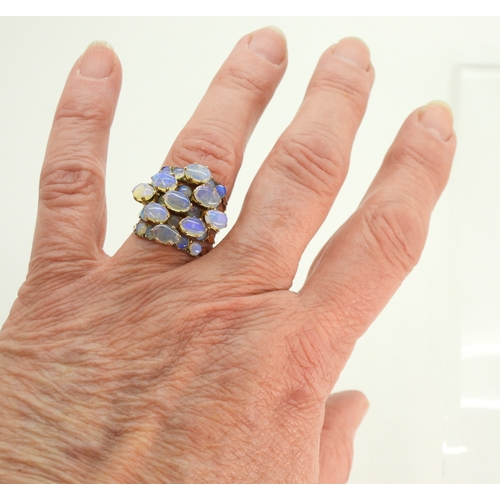 717 - A bright yellow metal five strand ring, each set with opals, size N1/2, weight 5.8gms