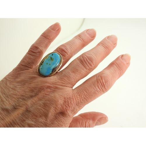 730 - A bright yellow metal turquoise set ring, size M, weight 9gms