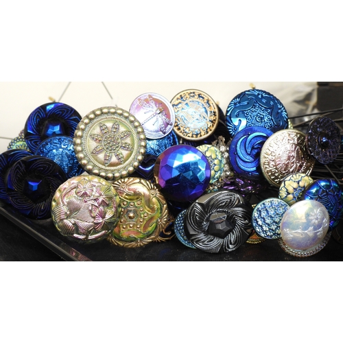 880 - A large collection of irridescent carnival glass hat pins, in various themes and colour ways, most w... 