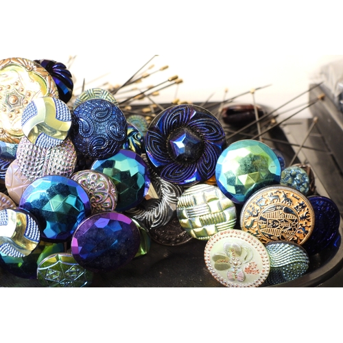 880 - A large collection of irridescent carnival glass hat pins, in various themes and colour ways, most w... 