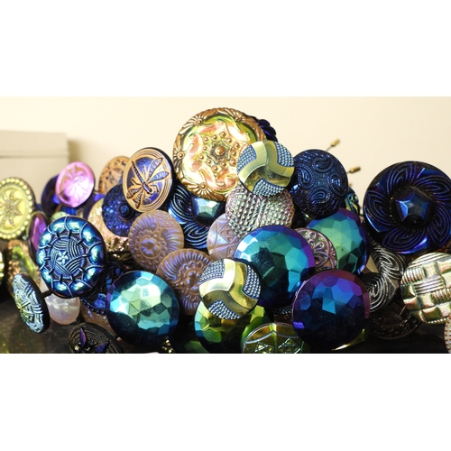 880 - A large collection of irridescent carnival glass hat pins, in various themes and colour ways, most w... 