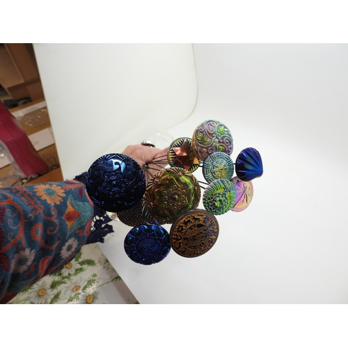 880 - A large collection of irridescent carnival glass hat pins, in various themes and colour ways, most w... 