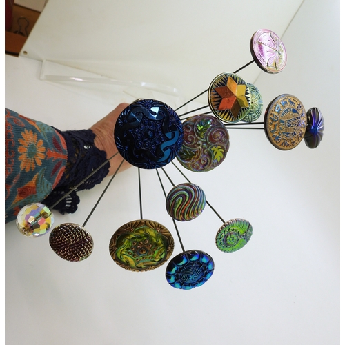 880 - A large collection of irridescent carnival glass hat pins, in various themes and colour ways, most w... 