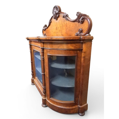 2040 - A VICTORIAN WALNUT VENEERED CREDENZAwith carved scrolled backsplash over central glazed doors flanke... 