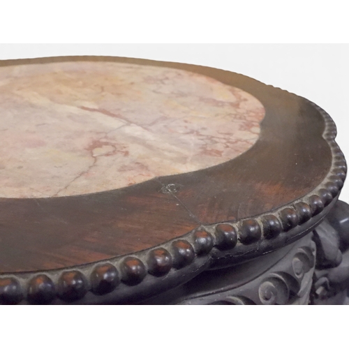 2050 - A 19TH CENTURY CHINESE HARDWOOD JARDINIERE STAND&nbsp;shaped marble inset top over carved pierced fr... 