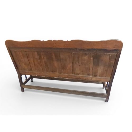2034 - A 17TH/18TH CENTURY OAK SIX PANEL BACKED SETTLEpanelled back carved with king and men at arms surmou... 