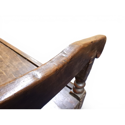2034 - A 17TH/18TH CENTURY OAK SIX PANEL BACKED SETTLEpanelled back carved with king and men at arms surmou... 
