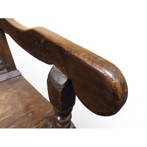 2034 - A 17TH/18TH CENTURY OAK SIX PANEL BACKED SETTLEpanelled back carved with king and men at arms surmou... 