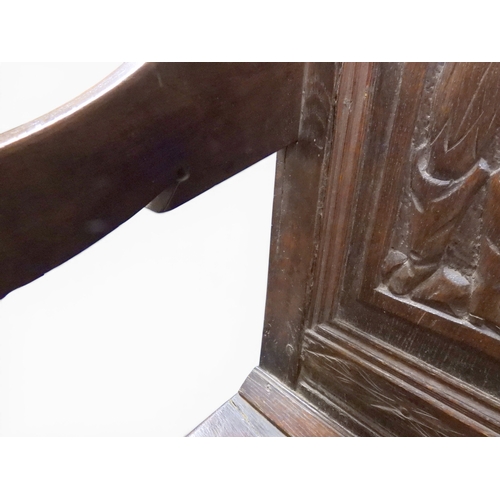 2034 - A 17TH/18TH CENTURY OAK SIX PANEL BACKED SETTLEpanelled back carved with king and men at arms surmou... 