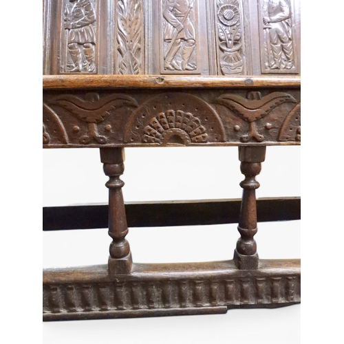 2034 - A 17TH/18TH CENTURY OAK SIX PANEL BACKED SETTLEpanelled back carved with king and men at arms surmou... 