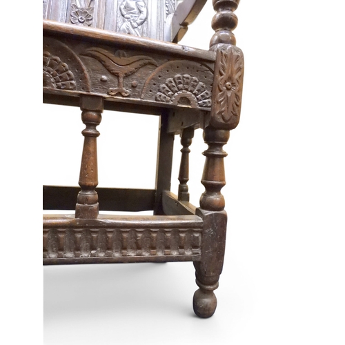 2034 - A 17TH/18TH CENTURY OAK SIX PANEL BACKED SETTLEpanelled back carved with king and men at arms surmou... 
