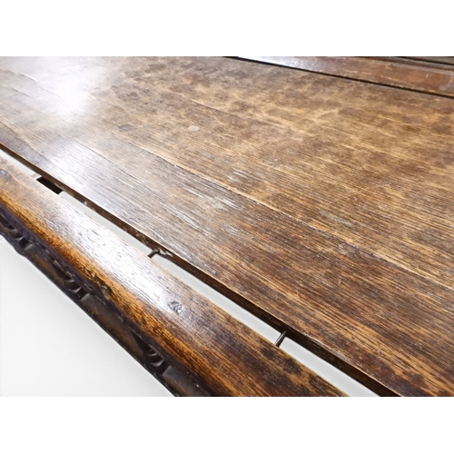2034 - A 17TH/18TH CENTURY OAK SIX PANEL BACKED SETTLEpanelled back carved with king and men at arms surmou... 