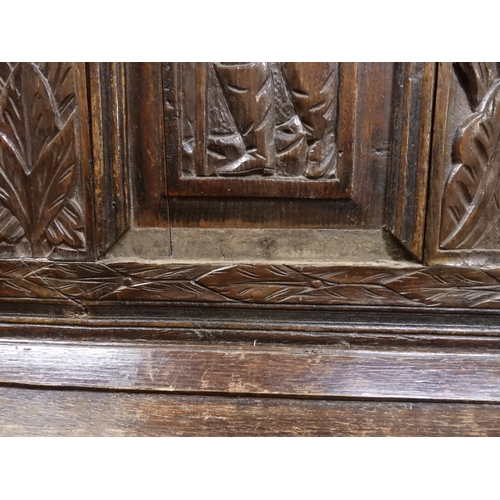 2034 - A 17TH/18TH CENTURY OAK SIX PANEL BACKED SETTLEpanelled back carved with king and men at arms surmou... 