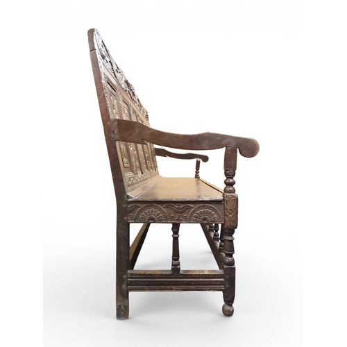 2034 - A 17TH/18TH CENTURY OAK SIX PANEL BACKED SETTLEpanelled back carved with king and men at arms surmou... 