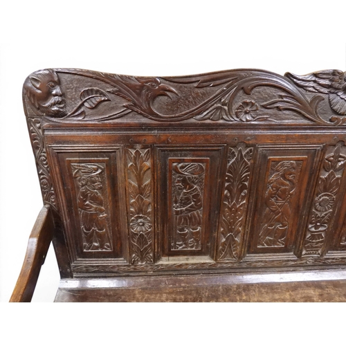 2034 - A 17TH/18TH CENTURY OAK SIX PANEL BACKED SETTLEpanelled back carved with king and men at arms surmou... 