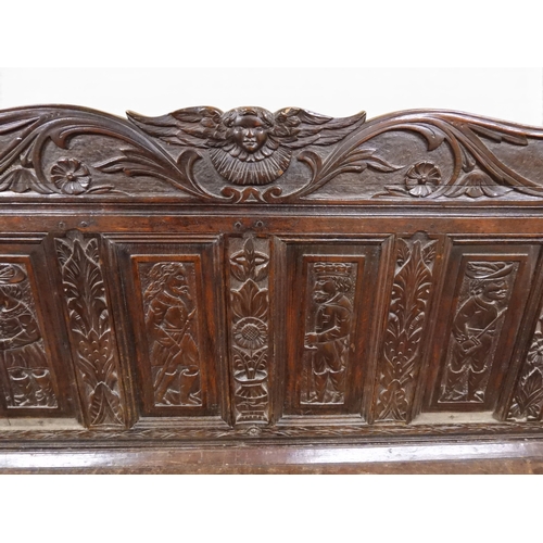 2034 - A 17TH/18TH CENTURY OAK SIX PANEL BACKED SETTLEpanelled back carved with king and men at arms surmou... 