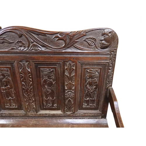 2034 - A 17TH/18TH CENTURY OAK SIX PANEL BACKED SETTLEpanelled back carved with king and men at arms surmou... 
