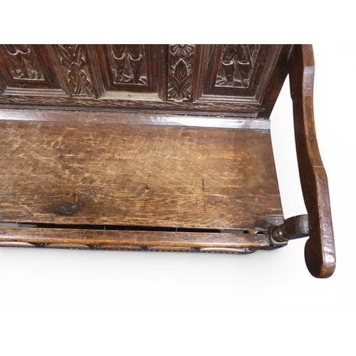 2034 - A 17TH/18TH CENTURY OAK SIX PANEL BACKED SETTLEpanelled back carved with king and men at arms surmou... 