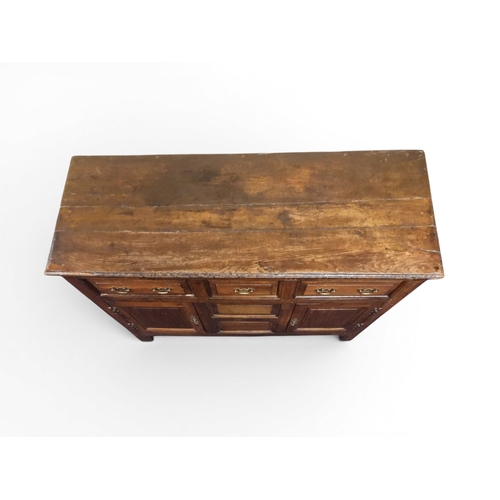 2035 - AN 18TH CENTURY OAK KITCHEN DRESSER BASEwith three plank top over three short drawers and panel cabi... 