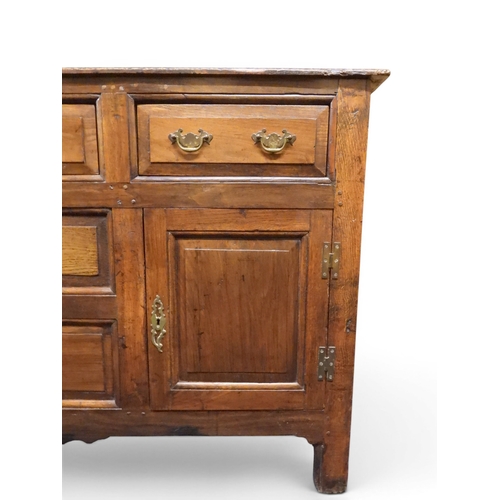 2035 - AN 18TH CENTURY OAK KITCHEN DRESSER BASEwith three plank top over three short drawers and panel cabi... 