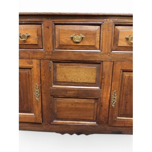 2035 - AN 18TH CENTURY OAK KITCHEN DRESSER BASEwith three plank top over three short drawers and panel cabi... 