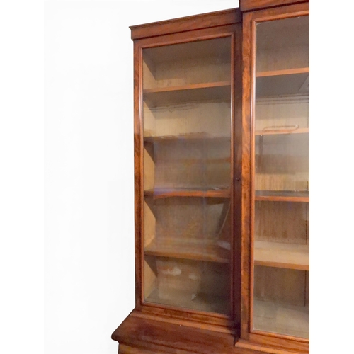 2055 - A LARGE VICTORIAN MAHOGANY BREAKFRONT LIBRARY BOOKCASEwith moulded cornice over four glazed doors on... 