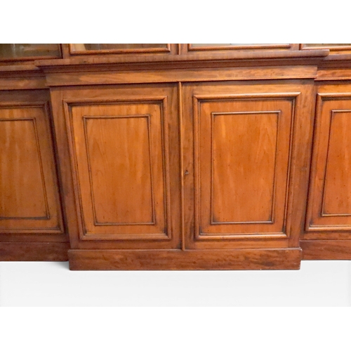 2055 - A LARGE VICTORIAN MAHOGANY BREAKFRONT LIBRARY BOOKCASEwith moulded cornice over four glazed doors on... 
