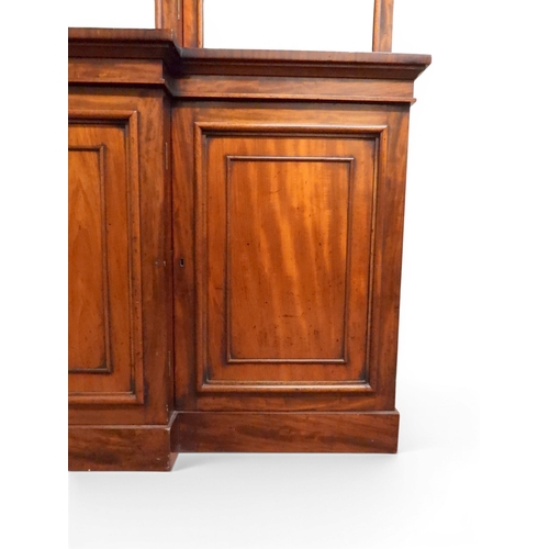 2055 - A LARGE VICTORIAN MAHOGANY BREAKFRONT LIBRARY BOOKCASEwith moulded cornice over four glazed doors on... 