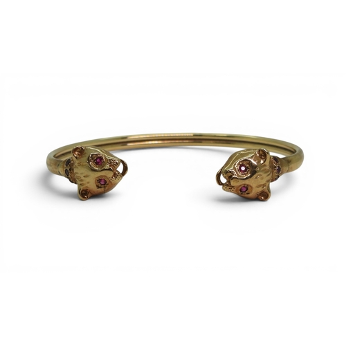 2756 - A LEOPARD BANGLEmade in 9ct gold and set with ruby eyes and collars. Inner diameter 6.2cm, weight 11... 