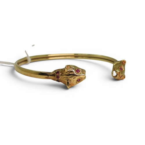 2756 - A LEOPARD BANGLEmade in 9ct gold and set with ruby eyes and collars. Inner diameter 6.2cm, weight 11... 