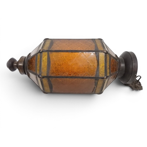 2004 - A LATE 19TH CENTURY MOROCCAN STYLE OCTAGONAL COPPER AND STAINED GLASS CANDLE LANTERNwith rise and fa... 