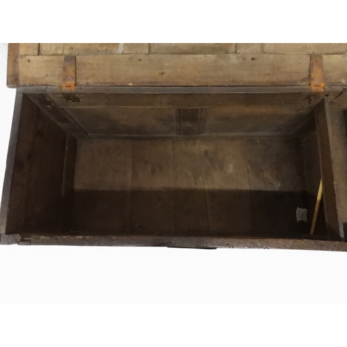 2022 - A 17TH/18TH CENTURY OAK BLANKET CHESTwith three panel lid with wrought iron fitting over carved thre... 
