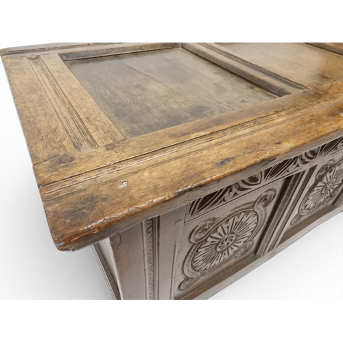 2022 - A 17TH/18TH CENTURY OAK BLANKET CHESTwith three panel lid with wrought iron fitting over carved thre... 