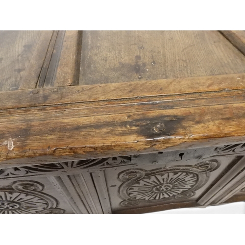 2022 - A 17TH/18TH CENTURY OAK BLANKET CHESTwith three panel lid with wrought iron fitting over carved thre... 