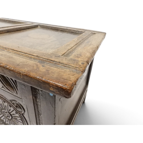 2022 - A 17TH/18TH CENTURY OAK BLANKET CHESTwith three panel lid with wrought iron fitting over carved thre... 