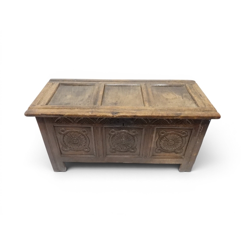 2022 - A 17TH/18TH CENTURY OAK BLANKET CHESTwith three panel lid with wrought iron fitting over carved thre... 