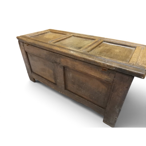 2022 - A 17TH/18TH CENTURY OAK BLANKET CHESTwith three panel lid with wrought iron fitting over carved thre... 