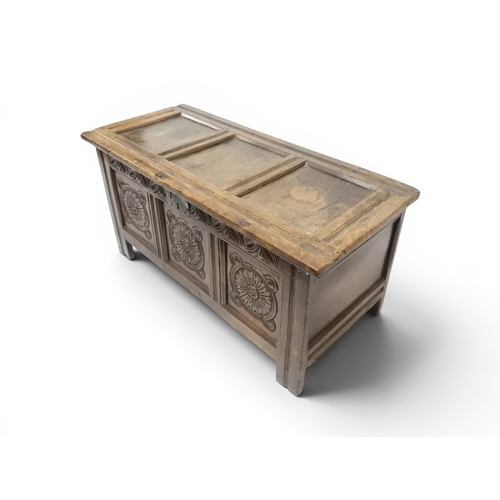 2022 - A 17TH/18TH CENTURY OAK BLANKET CHESTwith three panel lid with wrought iron fitting over carved thre... 