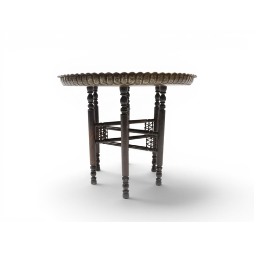 2023 - A 19TH/20TH CENTURY MOORISH COPPER TRAY TOP FOLDING TABLEcircular copper top with raised gallery edg... 