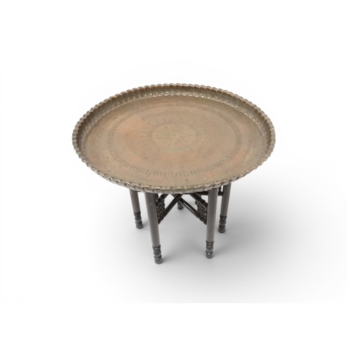 2023 - A 19TH/20TH CENTURY MOORISH COPPER TRAY TOP FOLDING TABLEcircular copper top with raised gallery edg... 