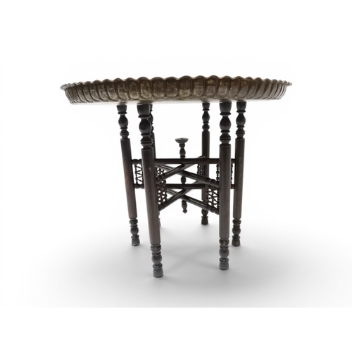 2023 - A 19TH/20TH CENTURY MOORISH COPPER TRAY TOP FOLDING TABLEcircular copper top with raised gallery edg... 