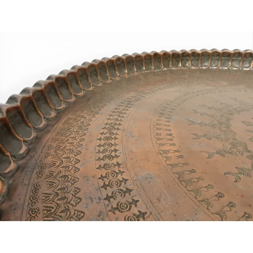 2023 - A 19TH/20TH CENTURY MOORISH COPPER TRAY TOP FOLDING TABLEcircular copper top with raised gallery edg... 