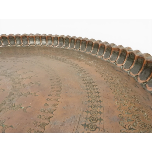2023 - A 19TH/20TH CENTURY MOORISH COPPER TRAY TOP FOLDING TABLEcircular copper top with raised gallery edg... 