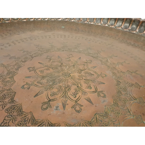 2023 - A 19TH/20TH CENTURY MOORISH COPPER TRAY TOP FOLDING TABLEcircular copper top with raised gallery edg... 