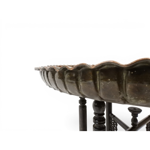 2023 - A 19TH/20TH CENTURY MOORISH COPPER TRAY TOP FOLDING TABLEcircular copper top with raised gallery edg... 